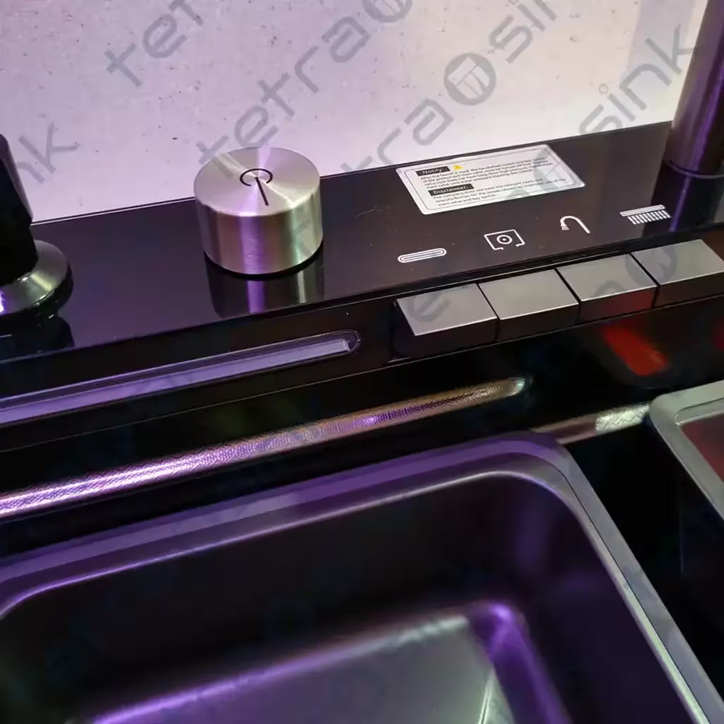 Close-up of a tetrasink kitchen sink with a metallic knob and control panel.